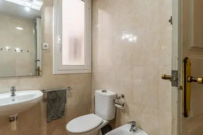 a bathroom with a white toilet and a sink at Canela Homes BARCELONA LESSEPS in Barcelona