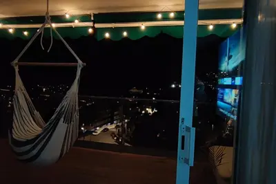 a hammock hanging from a window at night at Design Apartment with Sea View in Castelldefels