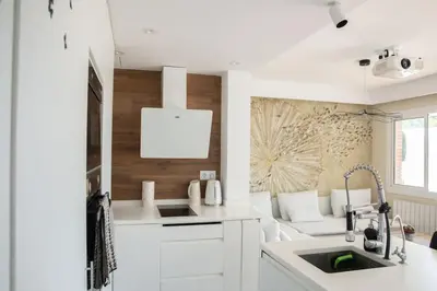 a white kitchen with a couch and a table at Design Apartment with Sea View in Castelldefels