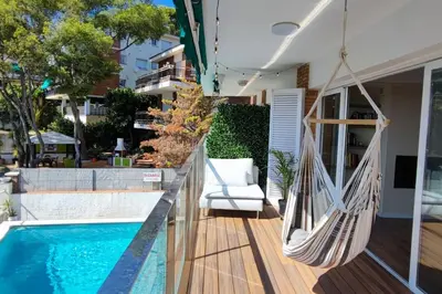 a porch with a hammock and a swimming pool at Design Apartment with Sea View in Castelldefels