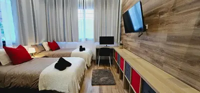 a hotel room with two beds and a flat screen tv at Gran apartamento ideal grupos muy cerca Barcelona in Badalona