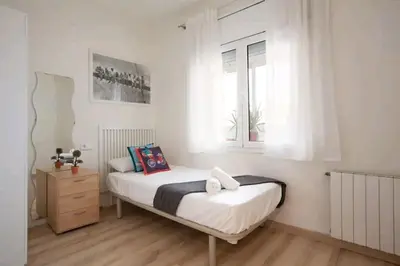 a small bedroom with a bed and a window at Centric Apartment Gran Via 5 in Hospitalet de Llobregat