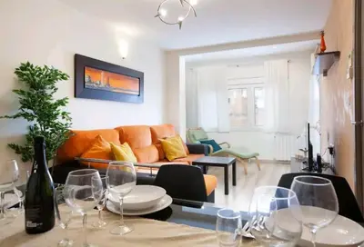 a living room with a couch and a table with wine glasses at Centric Apartment Gran Via 5 in Hospitalet de Llobregat