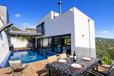 a villa with a swimming pool and a table and chairs at Catalunya Casas Modern Hilltop Haven with private pool 7km to beach in Castellet