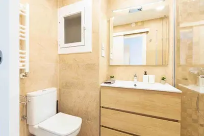 a bathroom with a toilet and a sink and a mirror at BEACHFRONT APARTMENT Castelldefels in Castelldefels