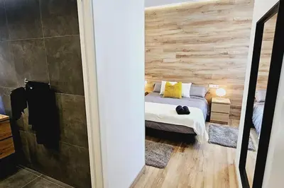 a bedroom with a bed and a wooden wall at apartamento premium muy cerca ciudad Barcelona in Badalona