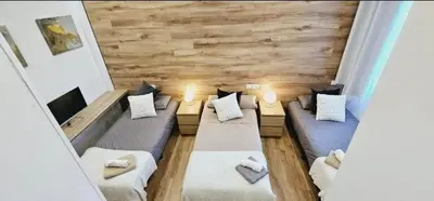 a living room with two beds and a tv at apartamento premium muy cerca ciudad Barcelona in Badalona