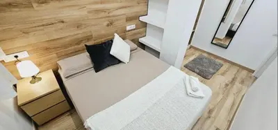 a small bedroom with a white bed and a table at apartamento premium muy cerca ciudad Barcelona in Badalona