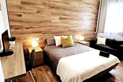 a bedroom with a bed and a wooden wall at apartamento premium muy cerca ciudad Barcelona in Badalona