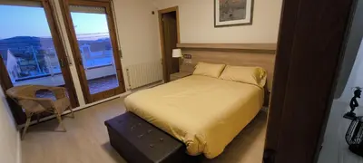 a bedroom with a bed and a large window at CAL LLOP in Sant Cugat de Sesgarrigues