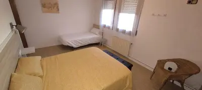 a room with a bed and a chair and a window at CAL LLOP in Sant Cugat de Sesgarrigues