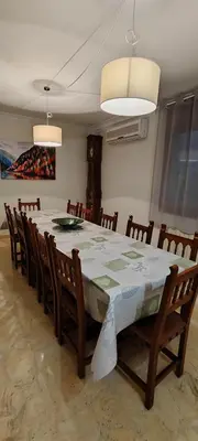a dining room table with chairs and a white table cloth at CAL LLOP in Sant Cugat de Sesgarrigues