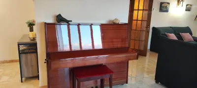 a wooden organ in a living room with a chair at CAL LLOP in Sant Cugat de Sesgarrigues