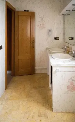 a bathroom with a sink and a mirror and a door at CAL LLOP in Sant Cugat de Sesgarrigues