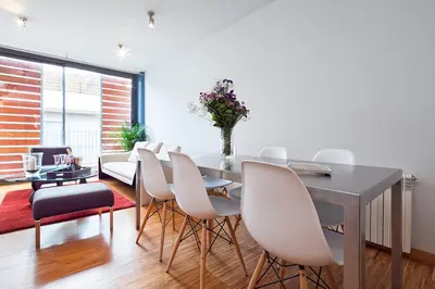 a dining room with a table and white chairs at My Space Emirates - Park Güell Triplex with Private Terrace in Barcelona