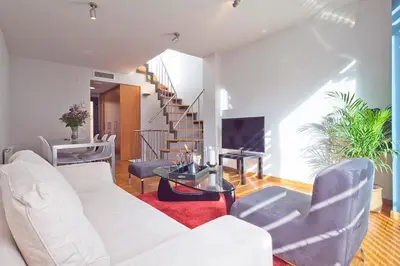 a living room with a white couch and a table at My Space Emirates - Park Güell Triplex with Private Terrace in Barcelona