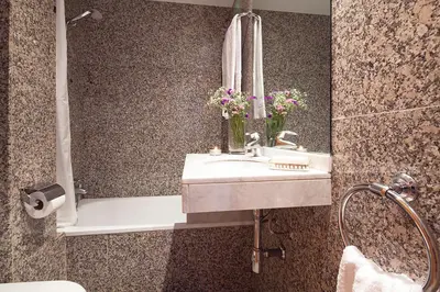 a bathroom with a sink and a bath tub with flowers at My Space Emirates - Park Güell Triplex with Private Terrace in Barcelona