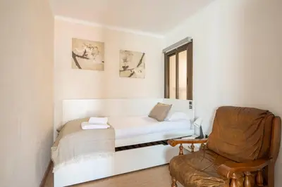 a small room with a bed and a chair at Apartamento 3 hab 15 minutos de Barcelona centro y 5 minutos playa in Sant Adria de Besos