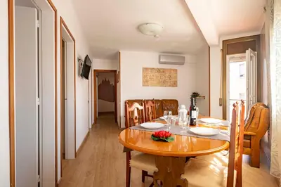 a dining room with a wooden table and chairs at Apartamento 3 hab 15 minutos de Barcelona centro y 5 minutos playa in Sant Adria de Besos