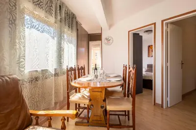 a dining room with a wooden table and chairs at Apartamento 3 hab 15 minutos de Barcelona centro y 5 minutos playa in Sant Adria de Besos