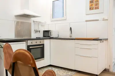 a kitchen with white cabinets and a microwave at Centric Apartment Molino P3 in Barcelona