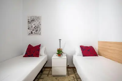 two white beds in a room with red pillows at Centric Molino Theatre 1-1 in Barcelona