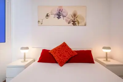 a bedroom with a white bed with two lamps at Centric Molino Theatre 1-1 in Barcelona