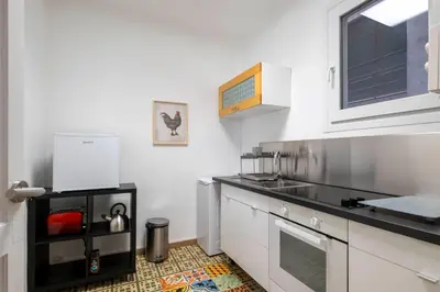 a kitchen with white cabinets and a black counter top at Centric Molino Theatre 1-1 in Barcelona