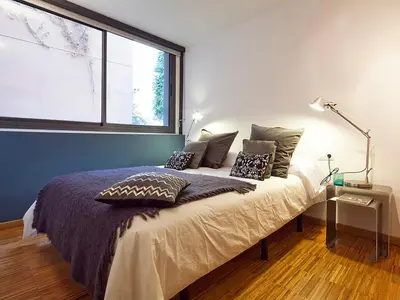a bedroom with a bed with pillows and a window at My Space Emirates - Charming Duplex in Barcelona ideal for Families or Friends in Barcelona
