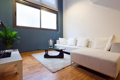 a living room with a white couch and a table at My Space Emirates - Charming Duplex in Barcelona ideal for Families or Friends in Barcelona