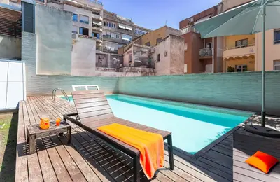 a swimming pool with a chair and an umbrella on a balcony at My Space Emirates - Splendid Apartment with Terrace and Pool near Park Güell in Barcelona
