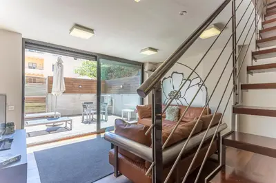 a living room with a couch and a staircase at My Space Emirates - Splendid Apartment with Terrace and Pool near Park Güell in Barcelona