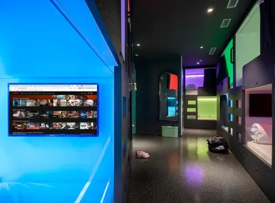 a hallway with a blue lighted room with a bed at AMISTAT City Hostel Barcelona in Barcelona