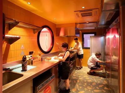a group of people preparing food in a kitchen at AMISTAT City Hostel Barcelona in Barcelona