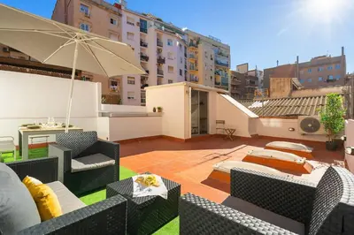 a patio with chairs and an umbrella on a building at Enamorats Glorias in Barcelona