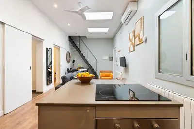 a kitchen with a counter top and a living room at Enamorats Glorias in Barcelona