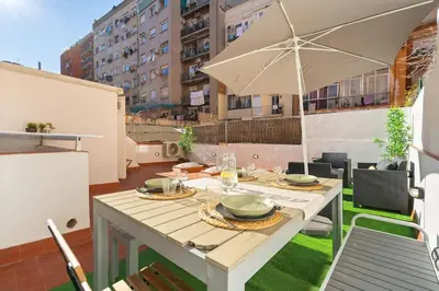 a dining table with an umbrella on a patio at Enamorats Glorias in Barcelona
