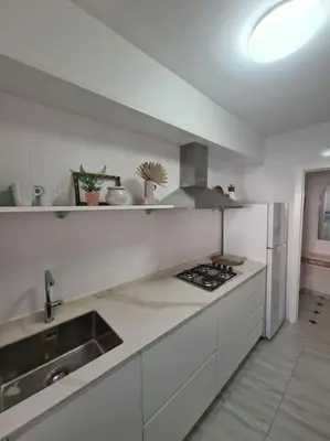 a white kitchen with a sink and a stove at Nice beachside 2-BD apt near Barcelona in Cunit