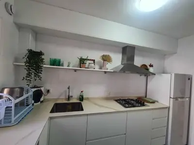 a white kitchen with a sink and a refrigerator at Nice beachside 2-BD apt near Barcelona in Cunit