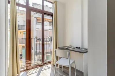a room with a desk and a large window at AB Margarit Apartments in Barcelona