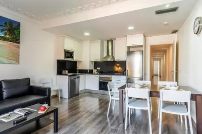 a kitchen and living room with a table and chairs at AB Margarit Apartments in Barcelona