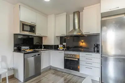a kitchen with white cabinets and stainless steel appliances at AB Margarit Apartments in Barcelona
