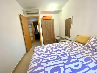 a bedroom with a bed with a purple and white comforter at Estancias mensuales Terrassa in Terrassa