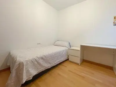 a small bedroom with a bed and a desk at Apartment Picasso in Vilanova i la Geltrú