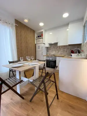 a kitchen with a table and chairs in a room at Ático con terraza! Ideal para vivir Sitges todo el año in Sitges