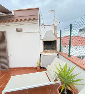 a balcony with a pizza oven on a white wall at Ático con terraza! Ideal para vivir Sitges todo el año in Sitges