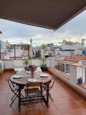 a table on a balcony with a view of a city at Ático con terraza! Ideal para vivir Sitges todo el año in Sitges