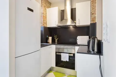 a kitchen with white cabinets and a stove top oven at Stay U-nique Apartments Vila de Gracia II in Barcelona