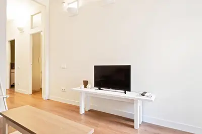a white living room with a tv on a white table at Stay U-nique Apartments Vila de Gracia II in Barcelona
