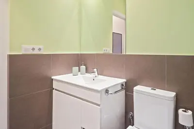 a bathroom with a sink and a toilet and a mirror at Stay U-nique Apartments Vila de Gracia II in Barcelona